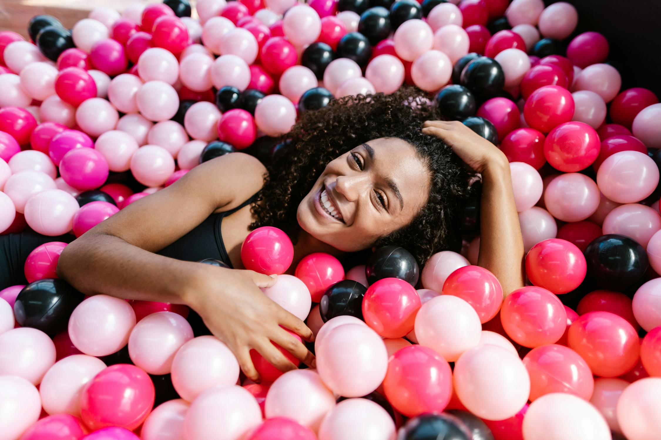 Cheerful woman in ball pit